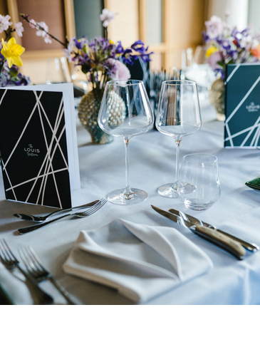 Meet & Enjoy l LOUIS Hotel München Elegant table decorations at the LOUIS Hotel Munich with flowers, glasses and stylish menu cards.